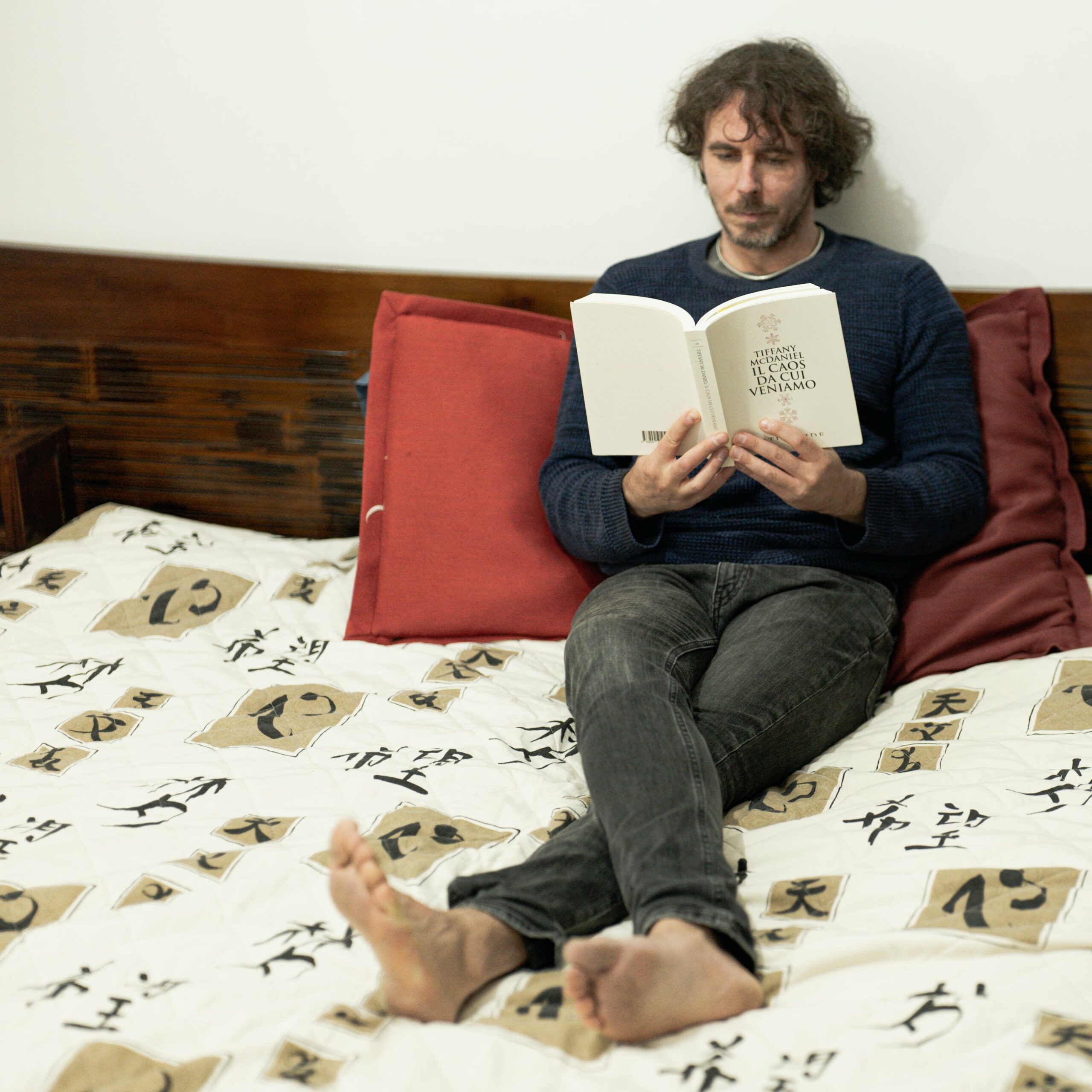 La foto mostra Francesco Trento in un momento di relax, sdraiato in camera sua mentre legge un romanzo di Tiffany McDaniel.